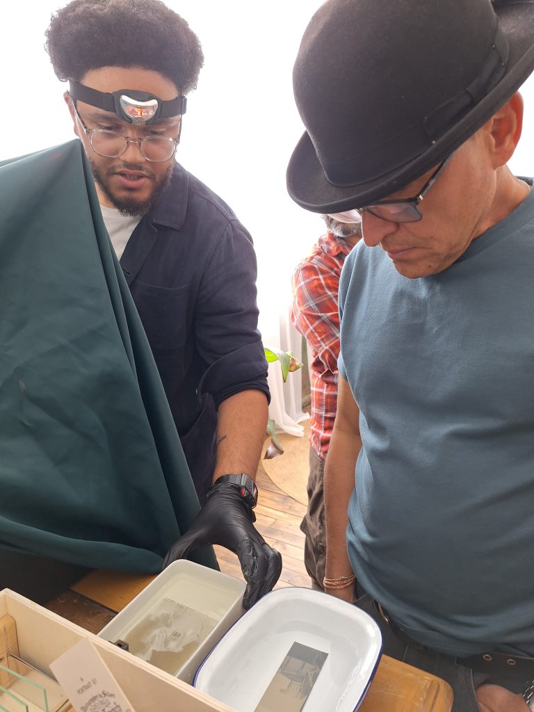 Shane watching Adam fix a n ambrotype.
