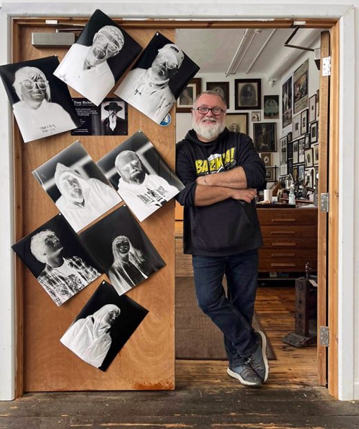Pic of me at my studio door covered in paper negatives.